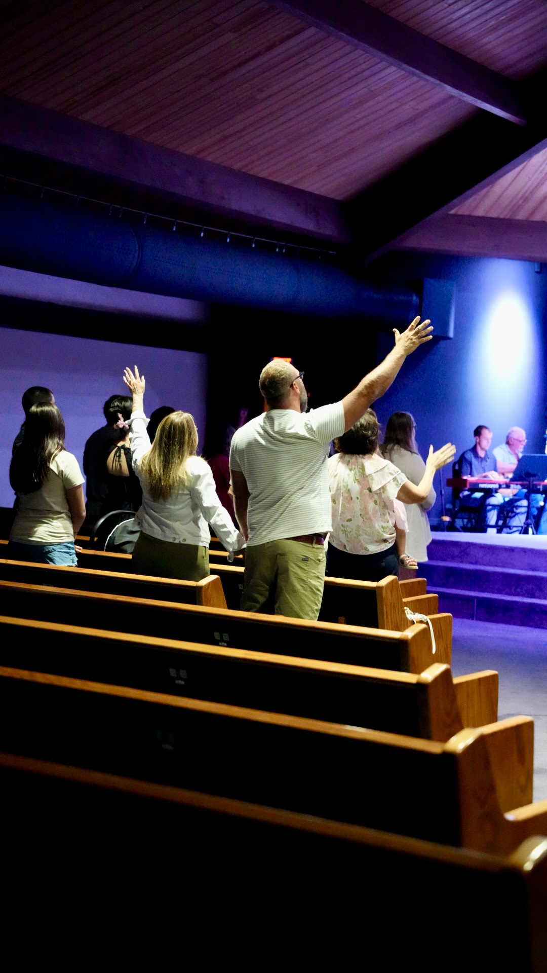 Worshippers with hands raised during a service