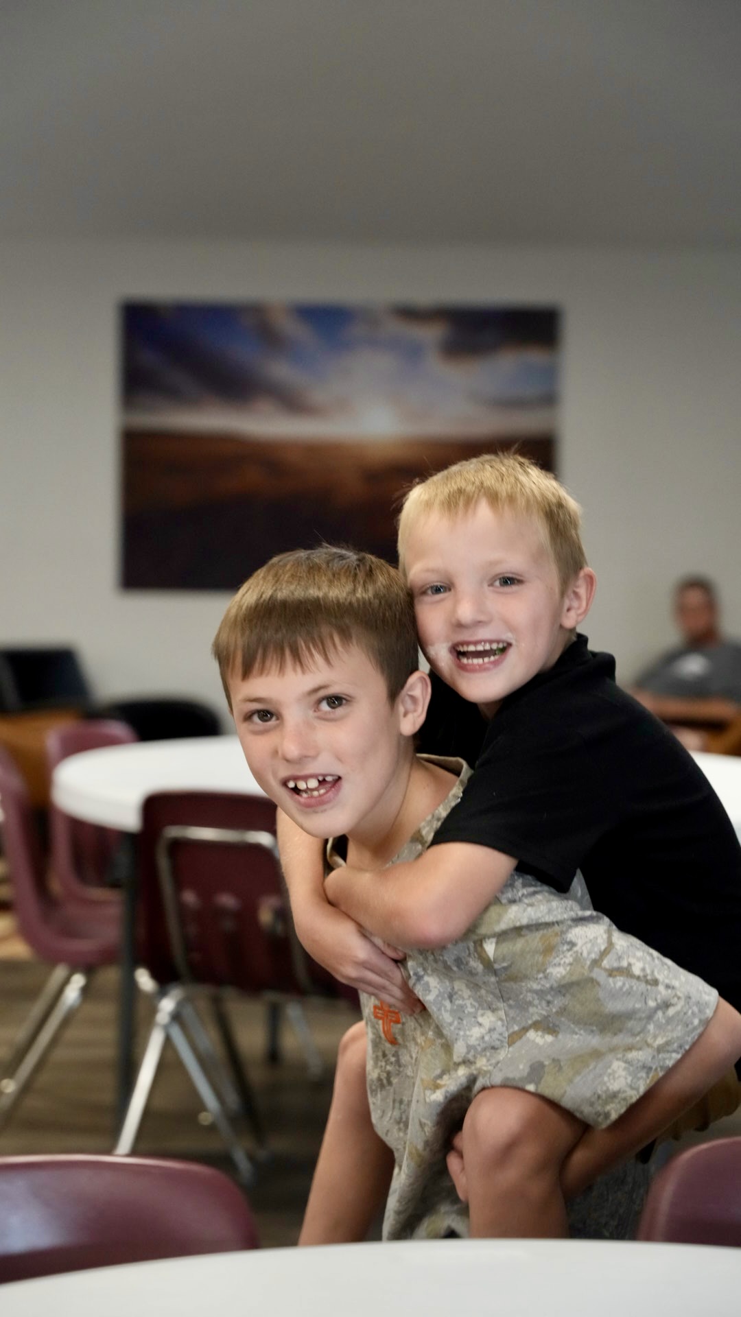 Two boys laughing together before service