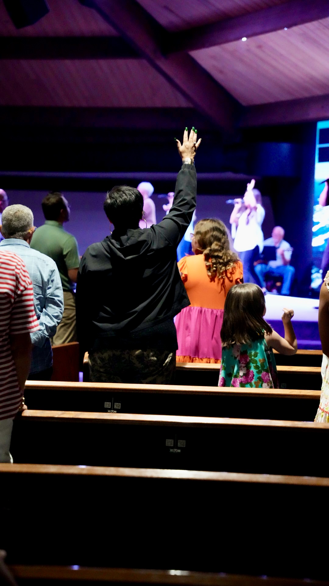 A woman worshipping with her hand raised