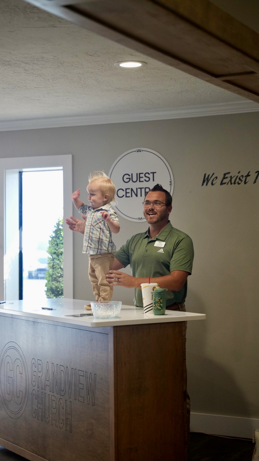 A volunteer and toddler at the Guest Central desk