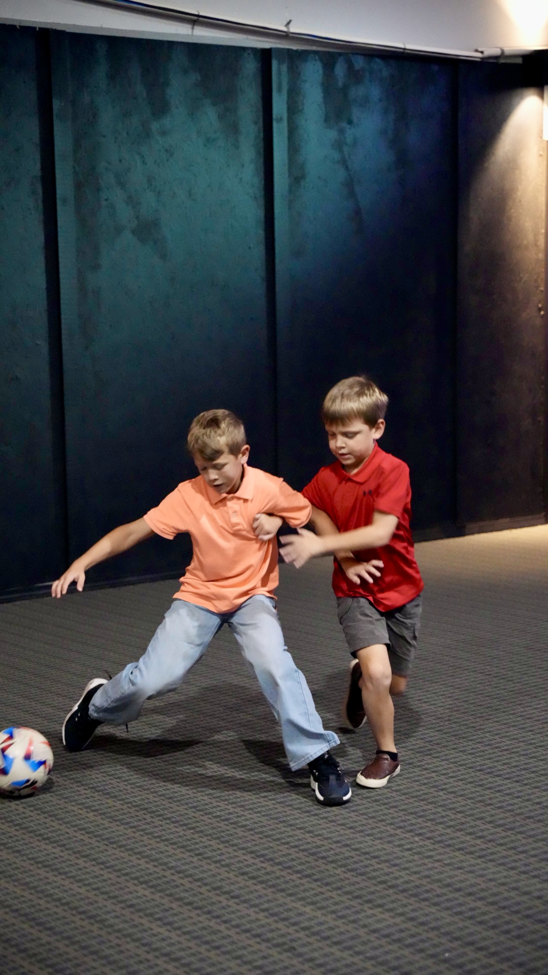 Two boys playing indoor soccer at church