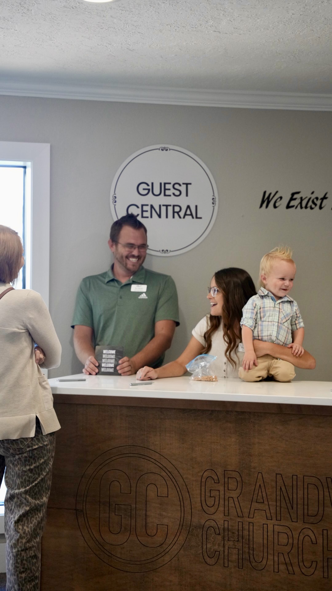 Volunteers welcoming a family at Guest Central