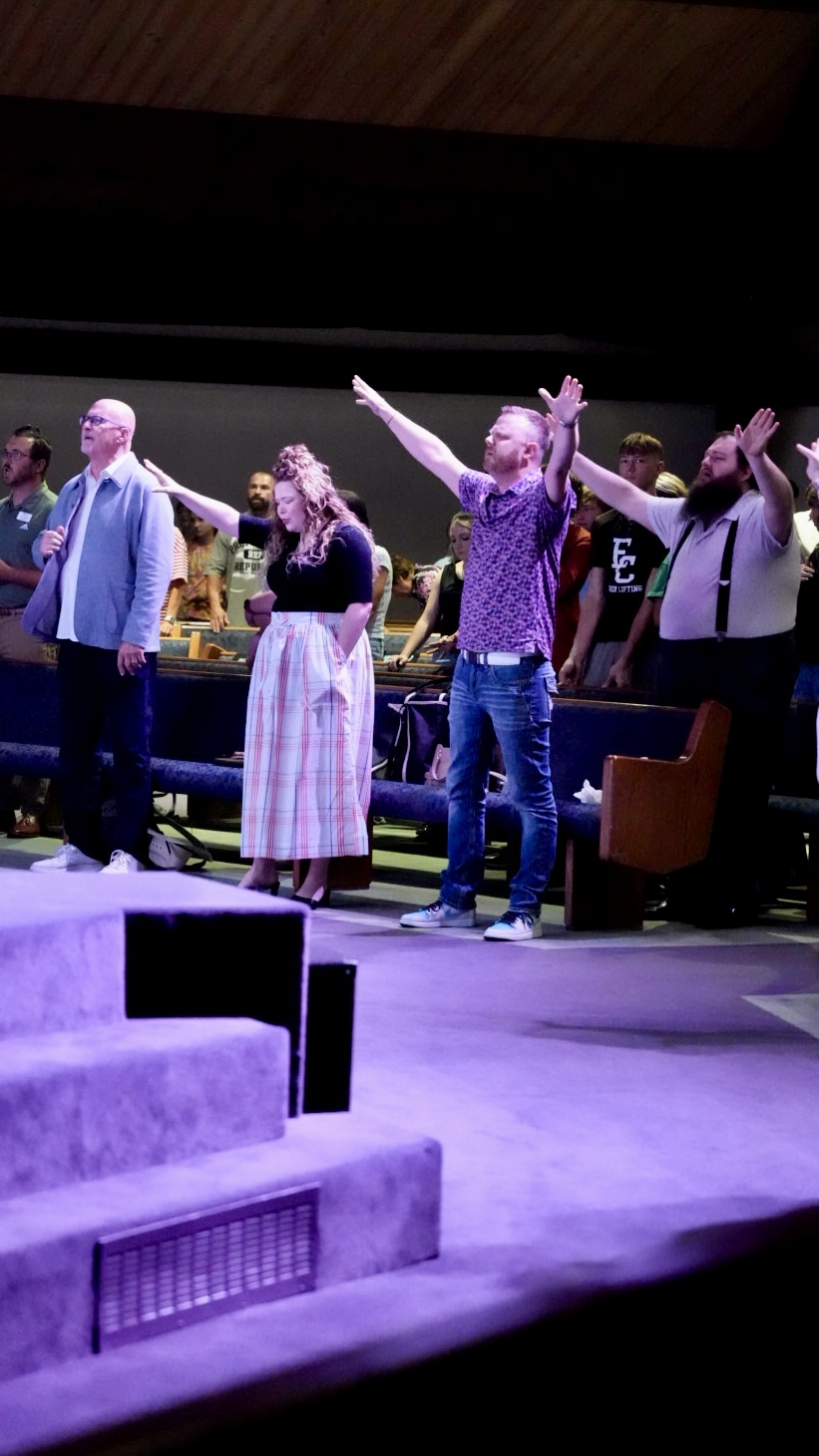 Worshippers standing at the front of the sanctuary