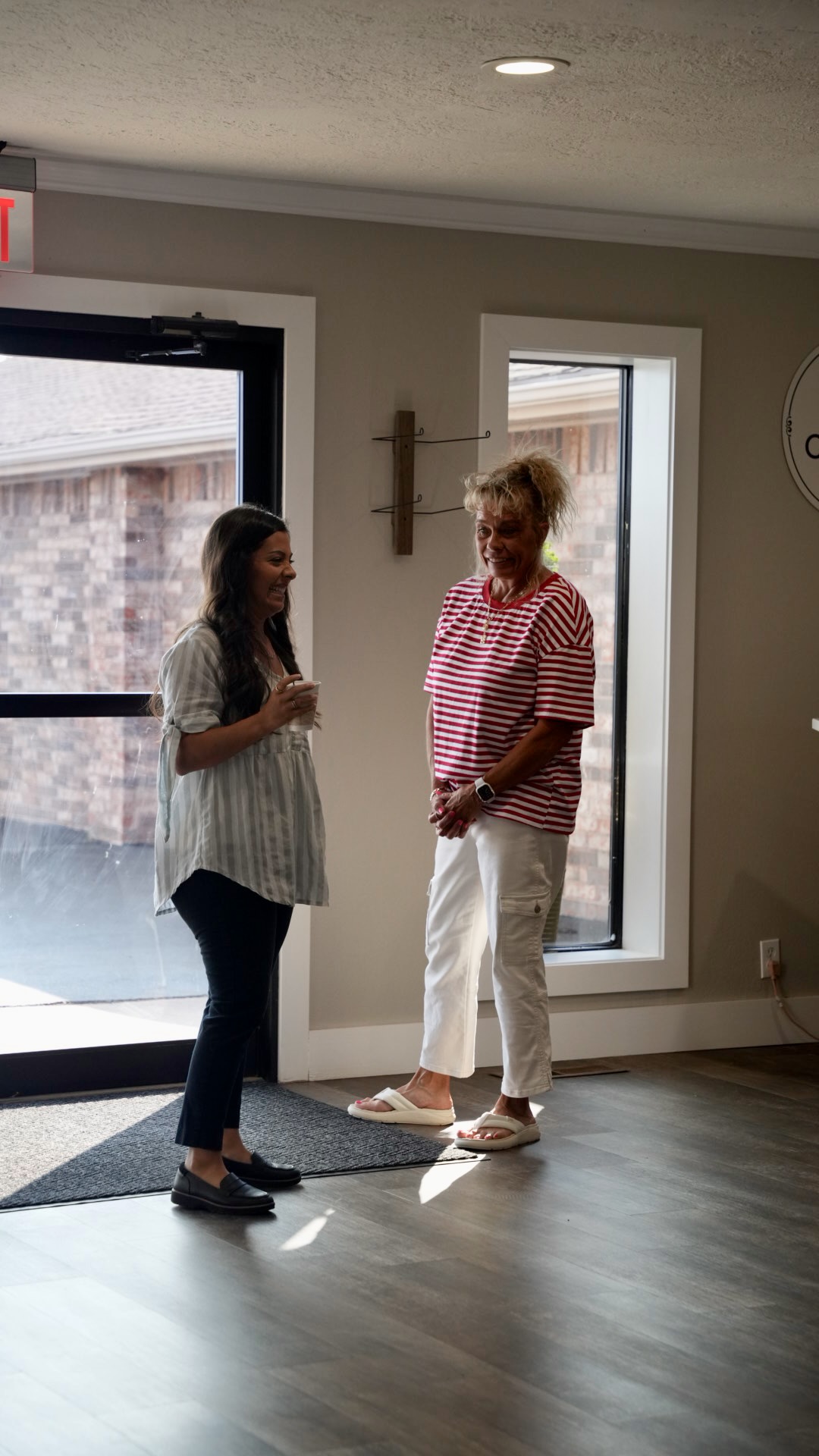 Two women laughing together near the entrance