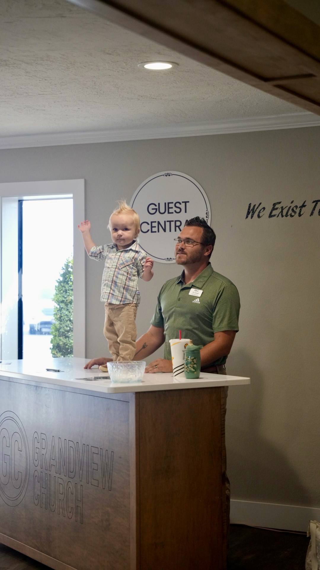 A toddler waving at the Grandview Church guest desk